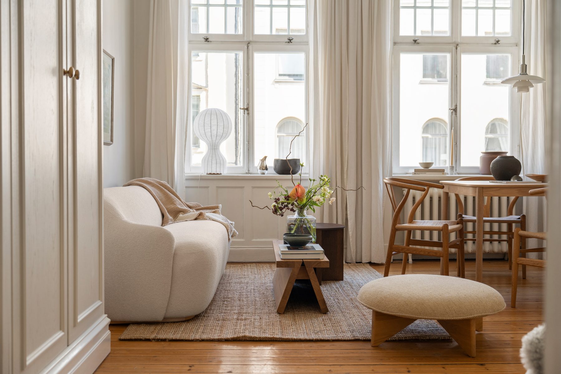 Soffa och matbord framför fönstren